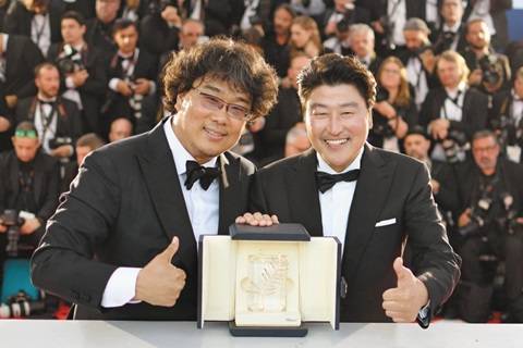 봉준호(왼쪽) 감독과 배우 송강호가 칸 영화제에서 황금종려상을 받고 포즈를 취하고 있다. /연합뉴스